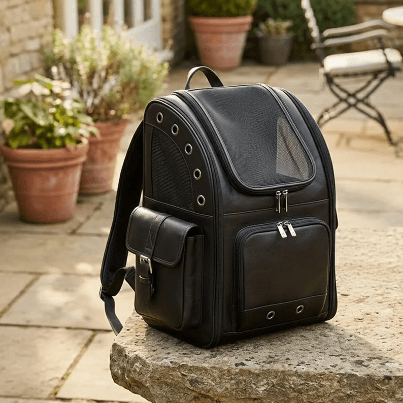 Pet Backpack Carrier | Genuine Leather A side-angled view of the premium leather Pet Backpack Carrier, showcasing the spacious side pocket with a buckle closure and the sleek, structured design of the backpack's frame.