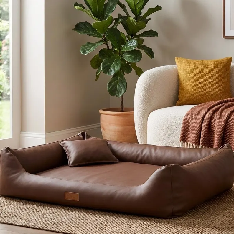 Leather Dog Bed | Luxury Handmade Pet Sofa Luxury leather dog bed styled in a modern living room next to a white textured sofa and a large potted fiddle-leaf fig plant, showcasing how the bed blends with high-end home decor.