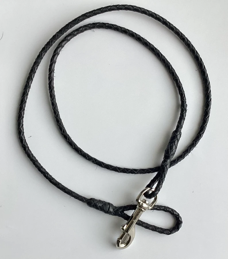 Leather Dog Leash | Braided Kangaroo Leather Dog Show Lead A top-down view of the black braided leather dog leash against a plain white background, showing the circular coil of the cord and the reinforced stitching near the silver metal clasp.