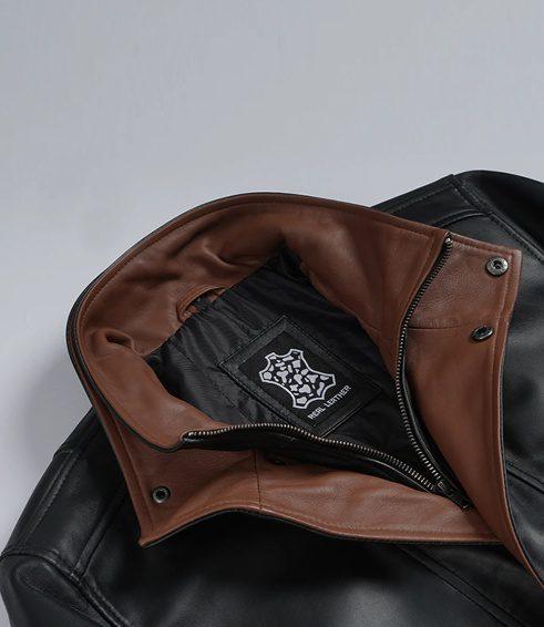 Men's Genuine Leather Jacket | Black and Brown Leather Jacket Close-up of the double-layer high stand collar on a black leather jacket, highlighting the rich brown real leather inner panel, sturdy front zipper, and an embroidered genuine leather patch on the inner lining.