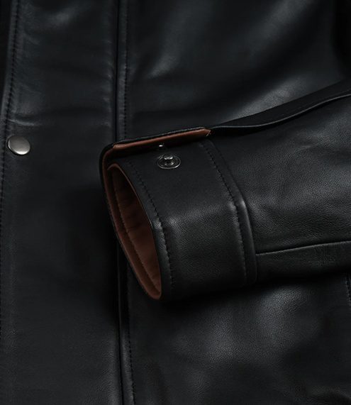 Men's Genuine Leather Jacket | Black and Brown Leather Jacket Close-up detail of the jacket's sleeve cuff showing the black genuine leather exterior, fine reinforced stitching, brown interior fabric lining, and a secure metallic snap-button closure.